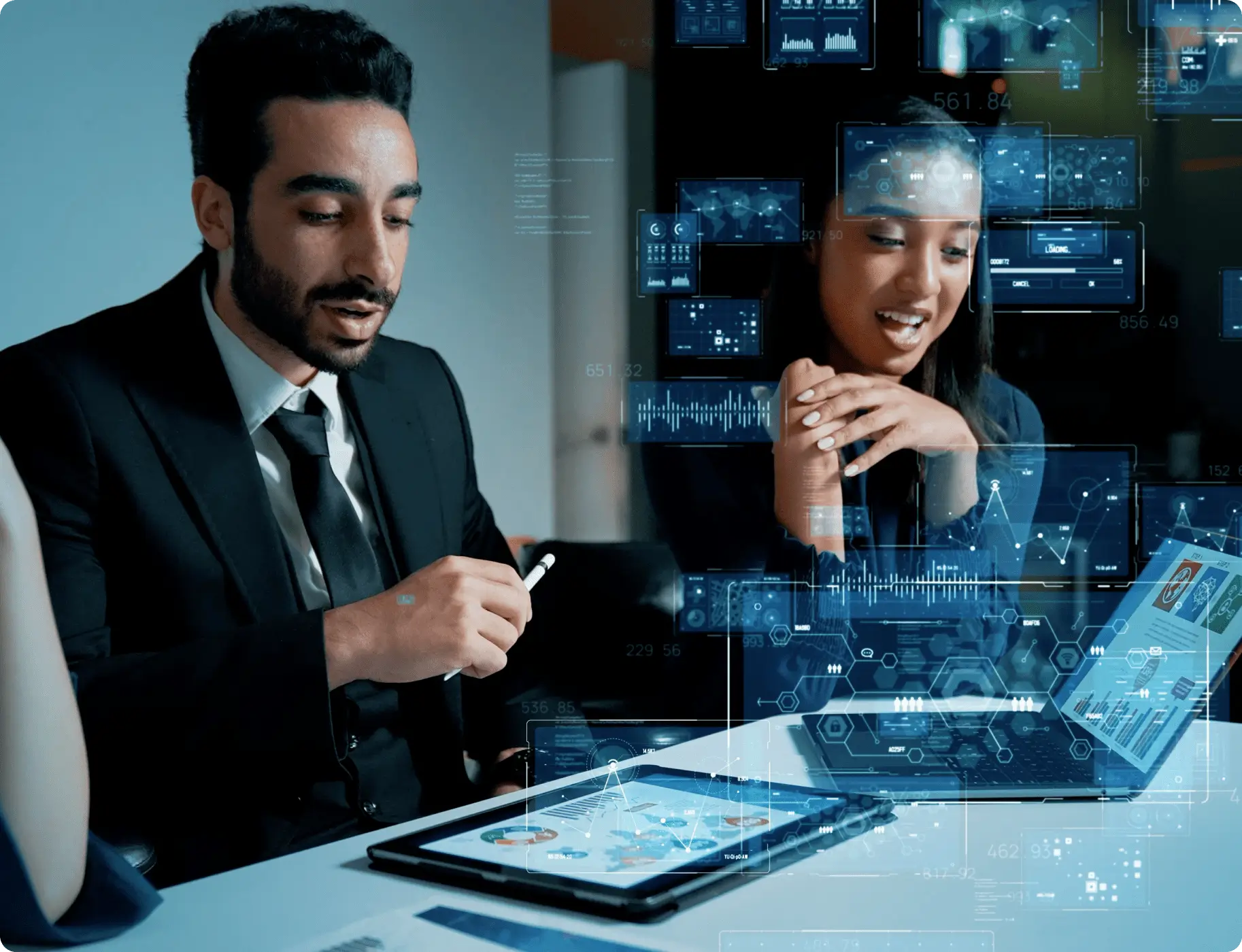 A man and woman sitting at a table with a tablet.